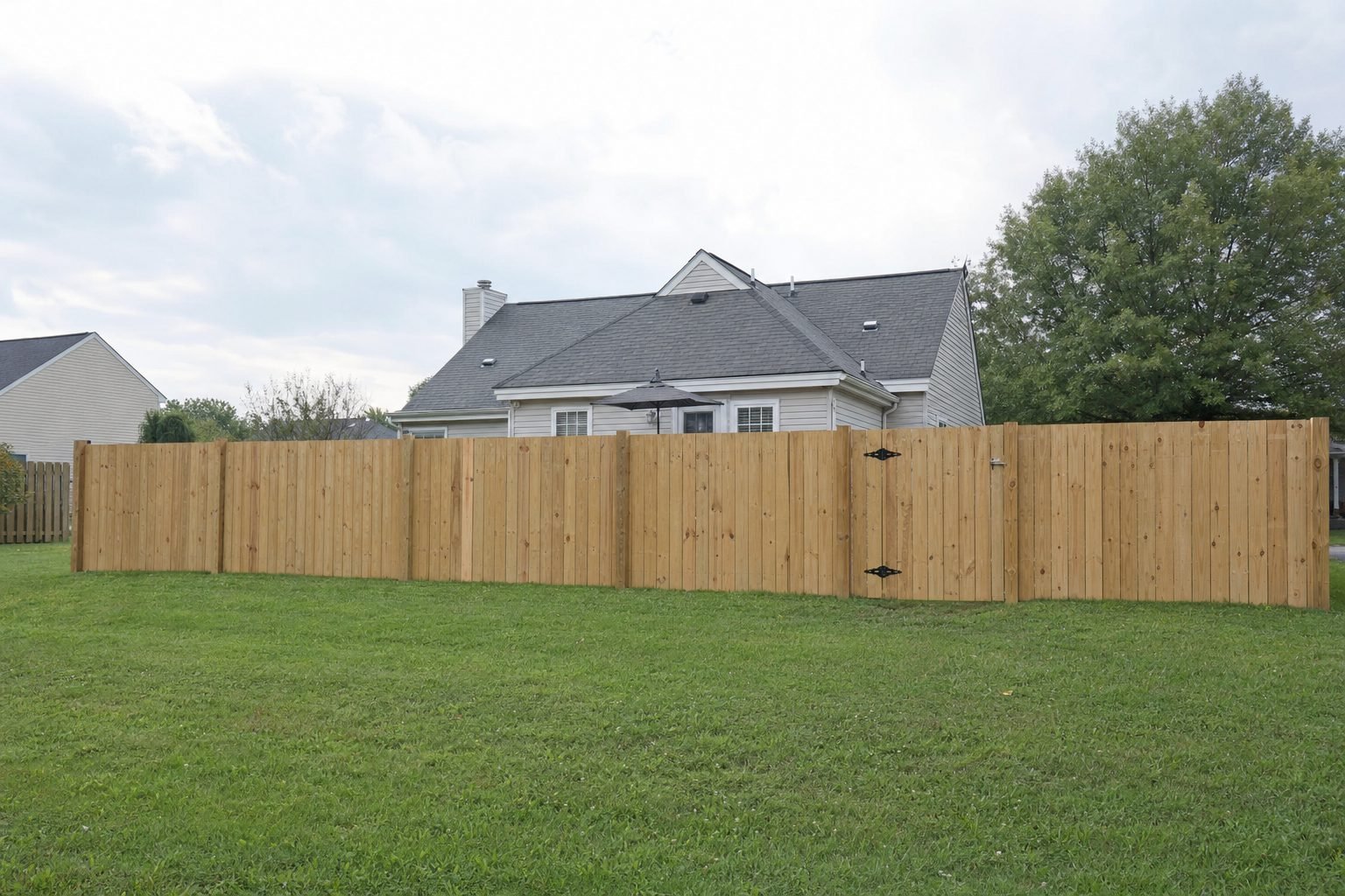 Newly installed fence lining a manicured backyard in Fayetteville, NC